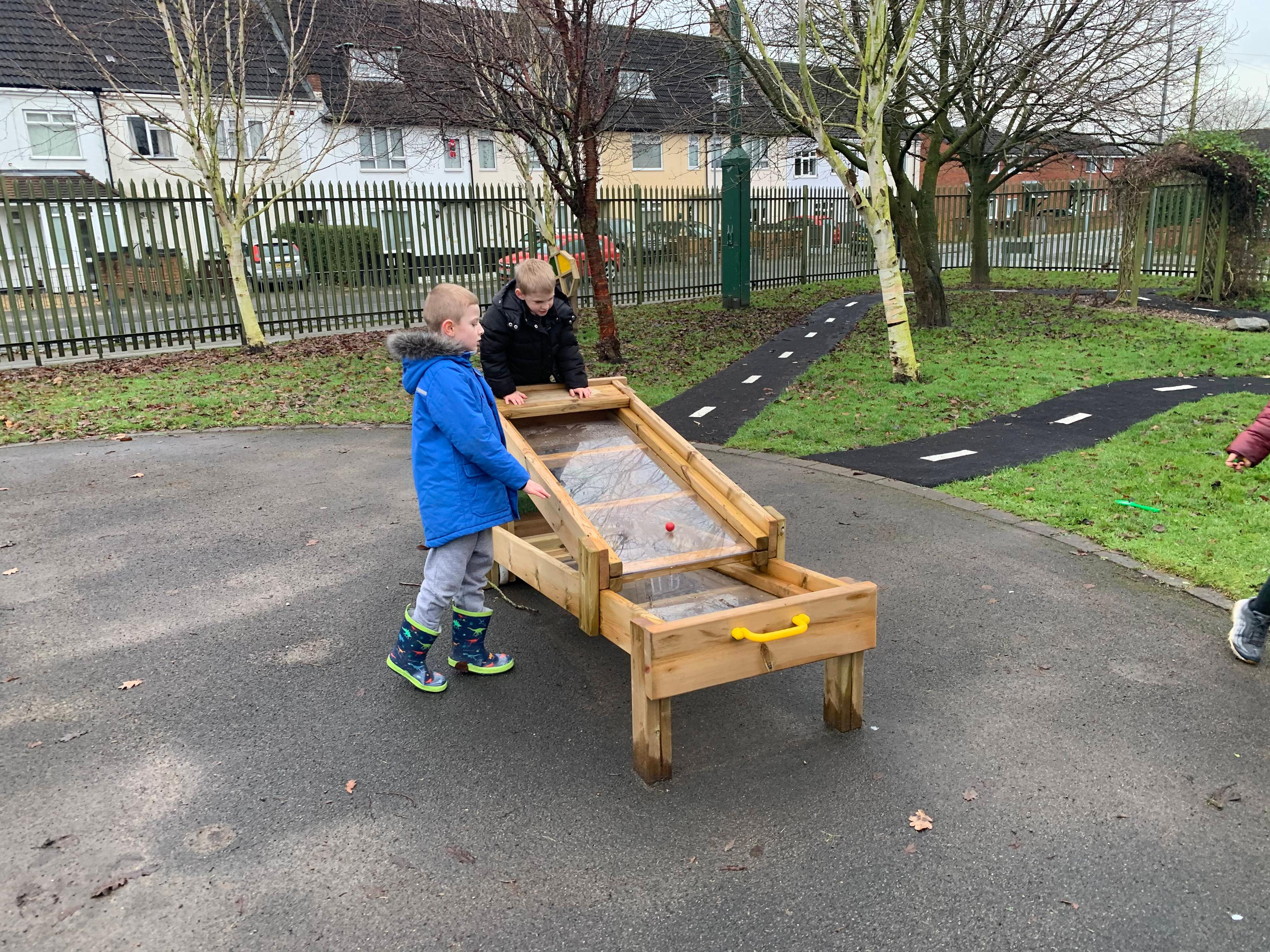 Two young boys playing and experimenting with the Pentagon Play flow table