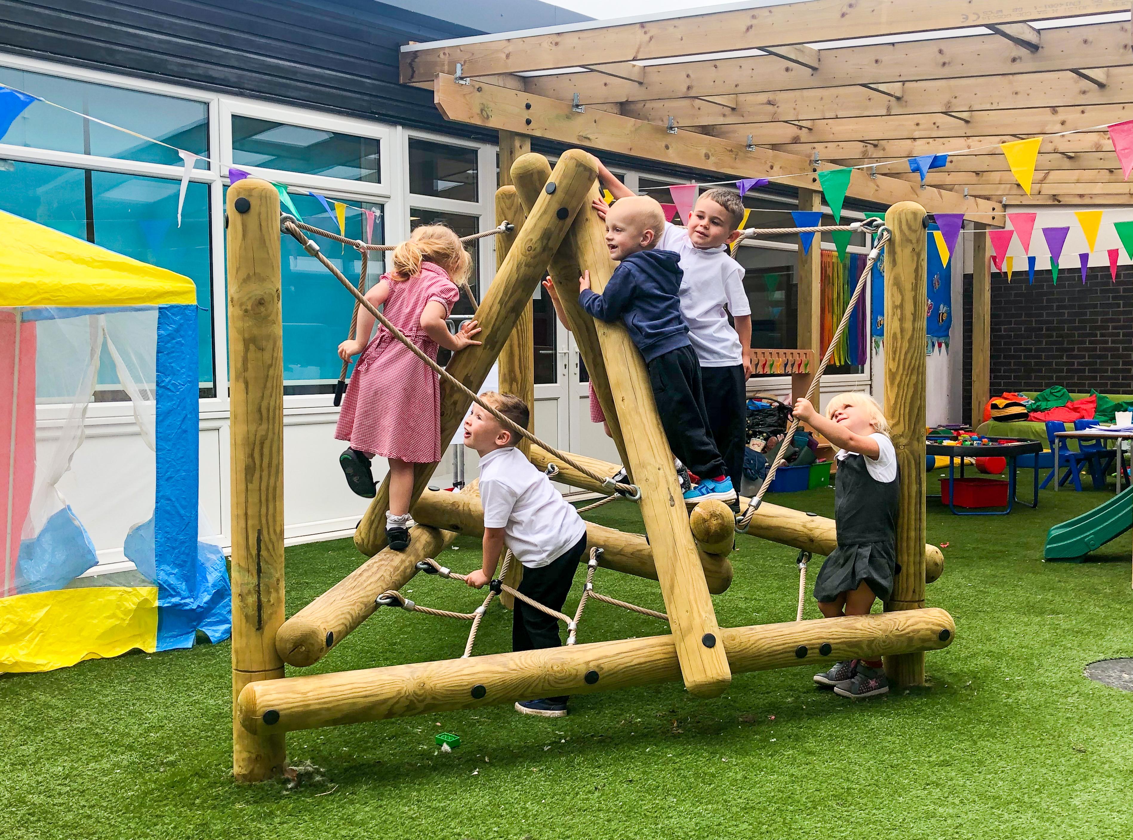 A group of nursery children playing on the pinnacle hill climber