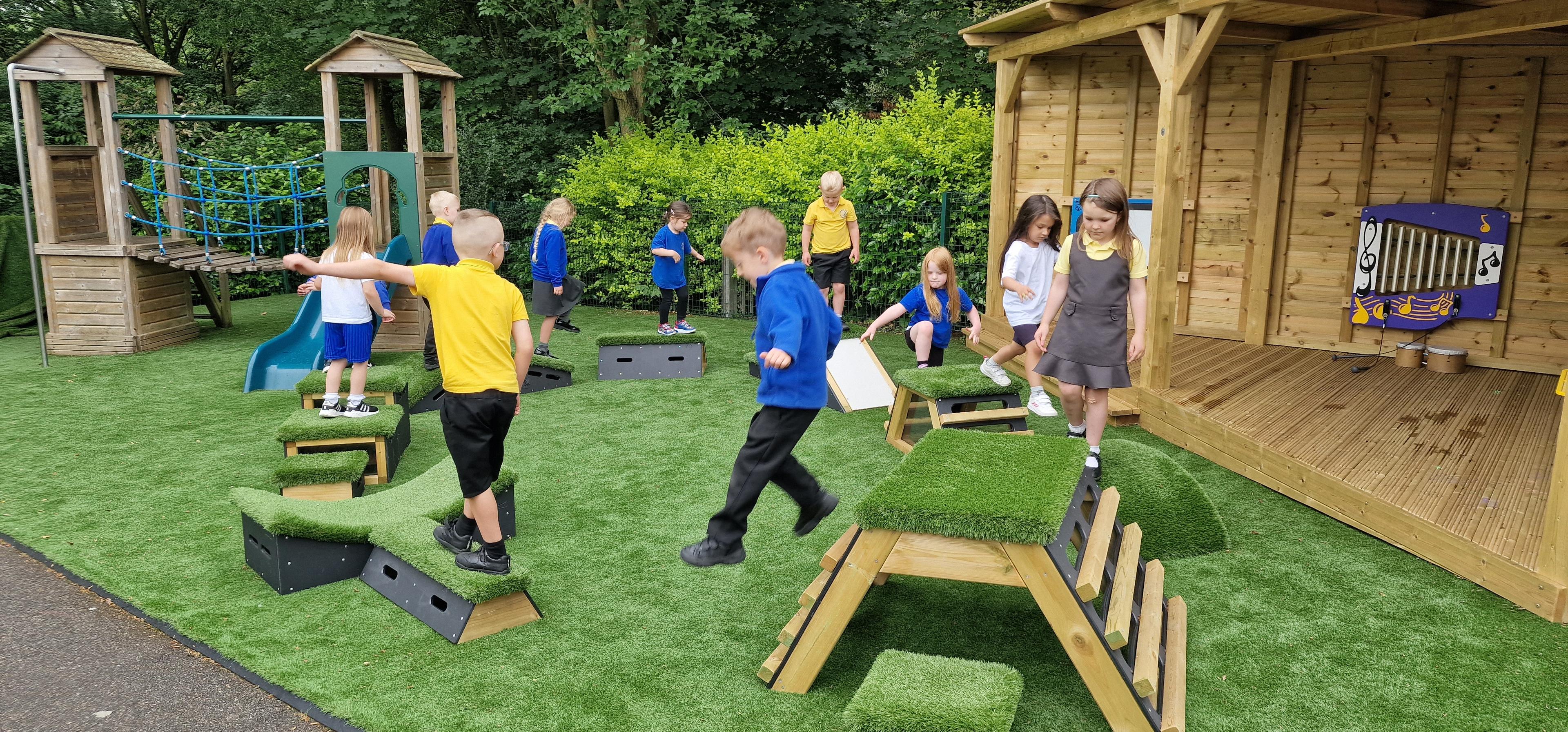 Primary School children playing out outside on grass-topped Get Set, Go! Blocks - Cheviot Set.