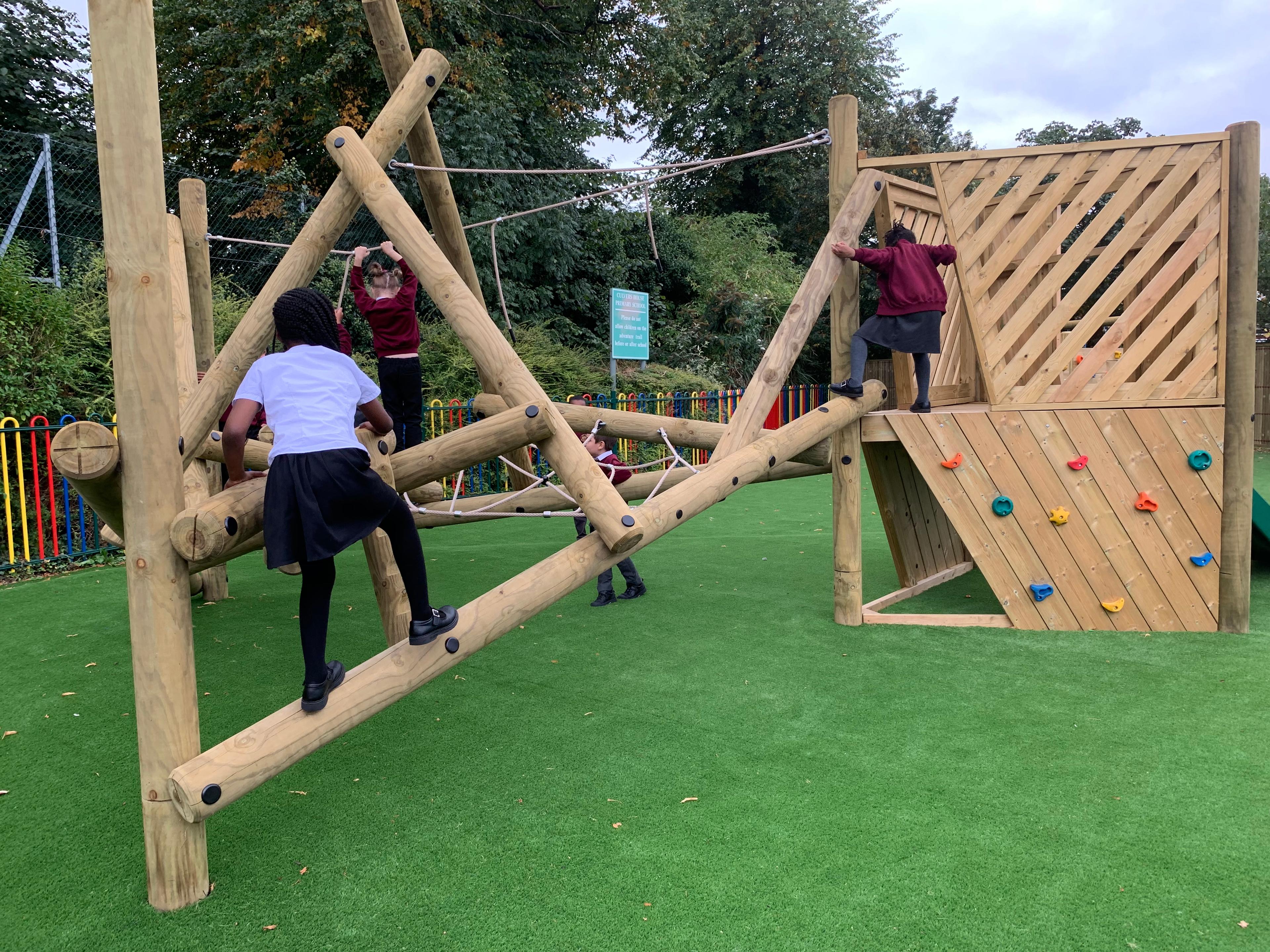 Wooden Bowfell Climbing Frame with Platform and Slide in school playground.