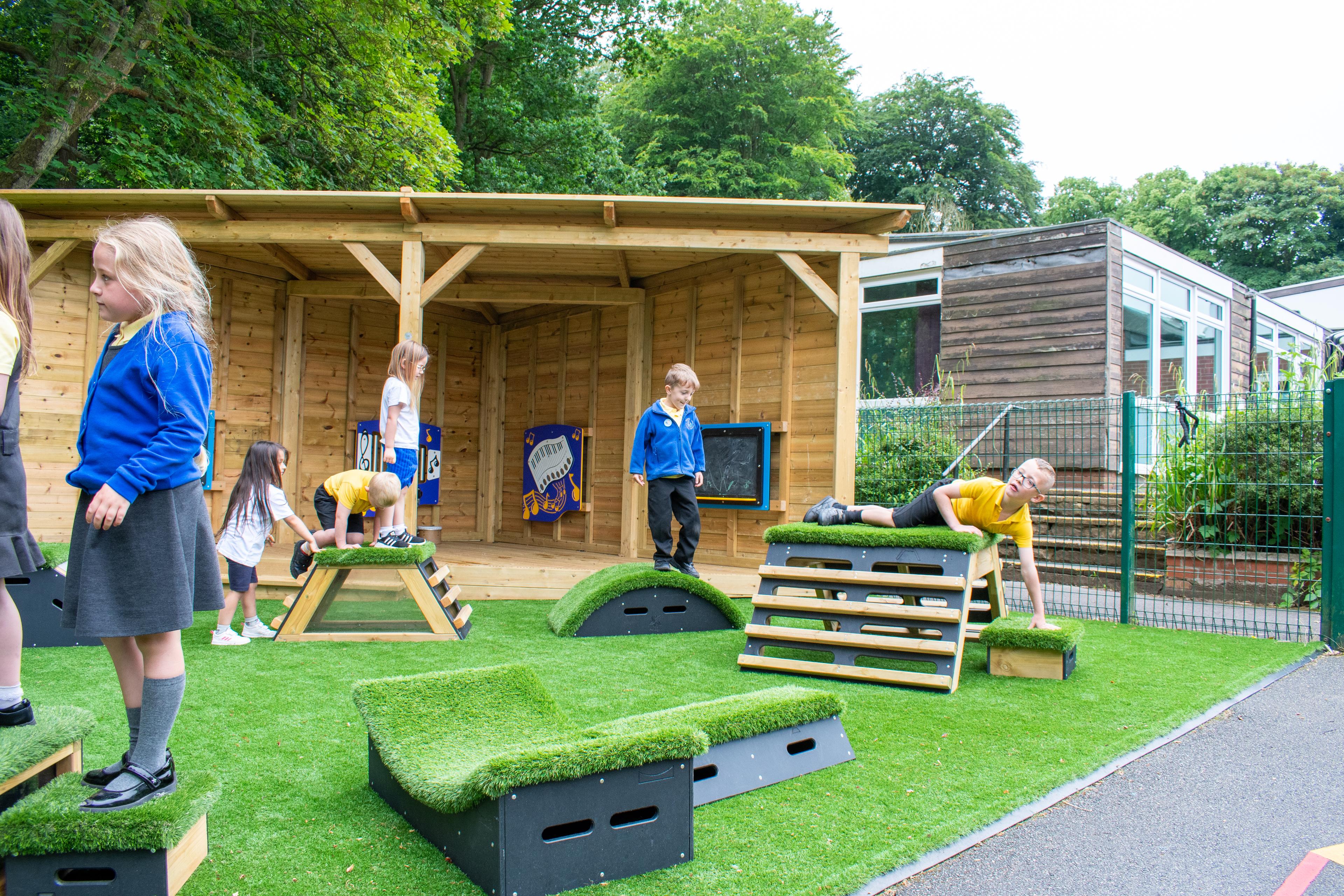 Primary School children playing out outside on grass-topped Get Set, Go! Blocks - Cheviot Set.