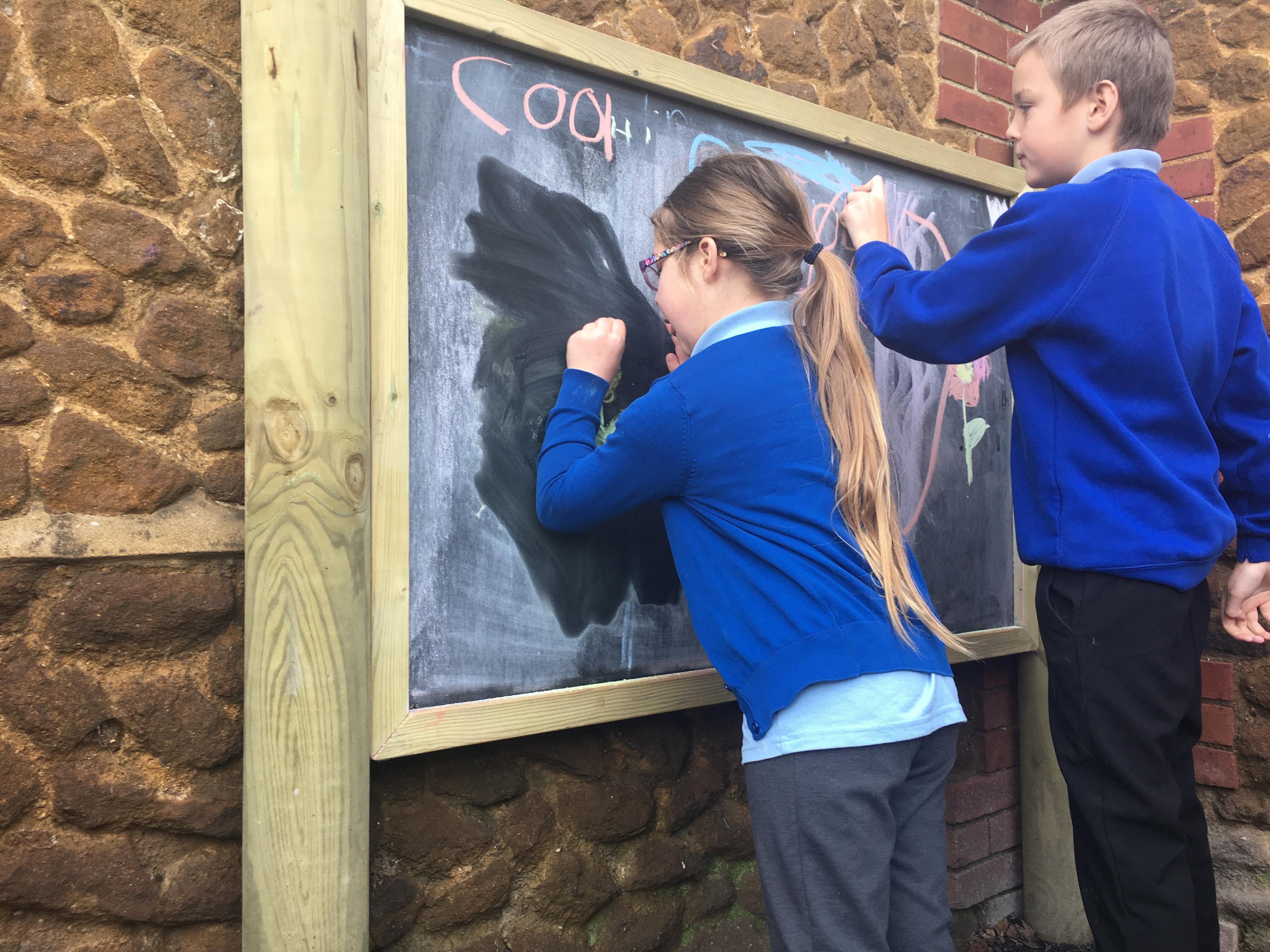 Giant wooden chalkboard on posts from Pentagon Play