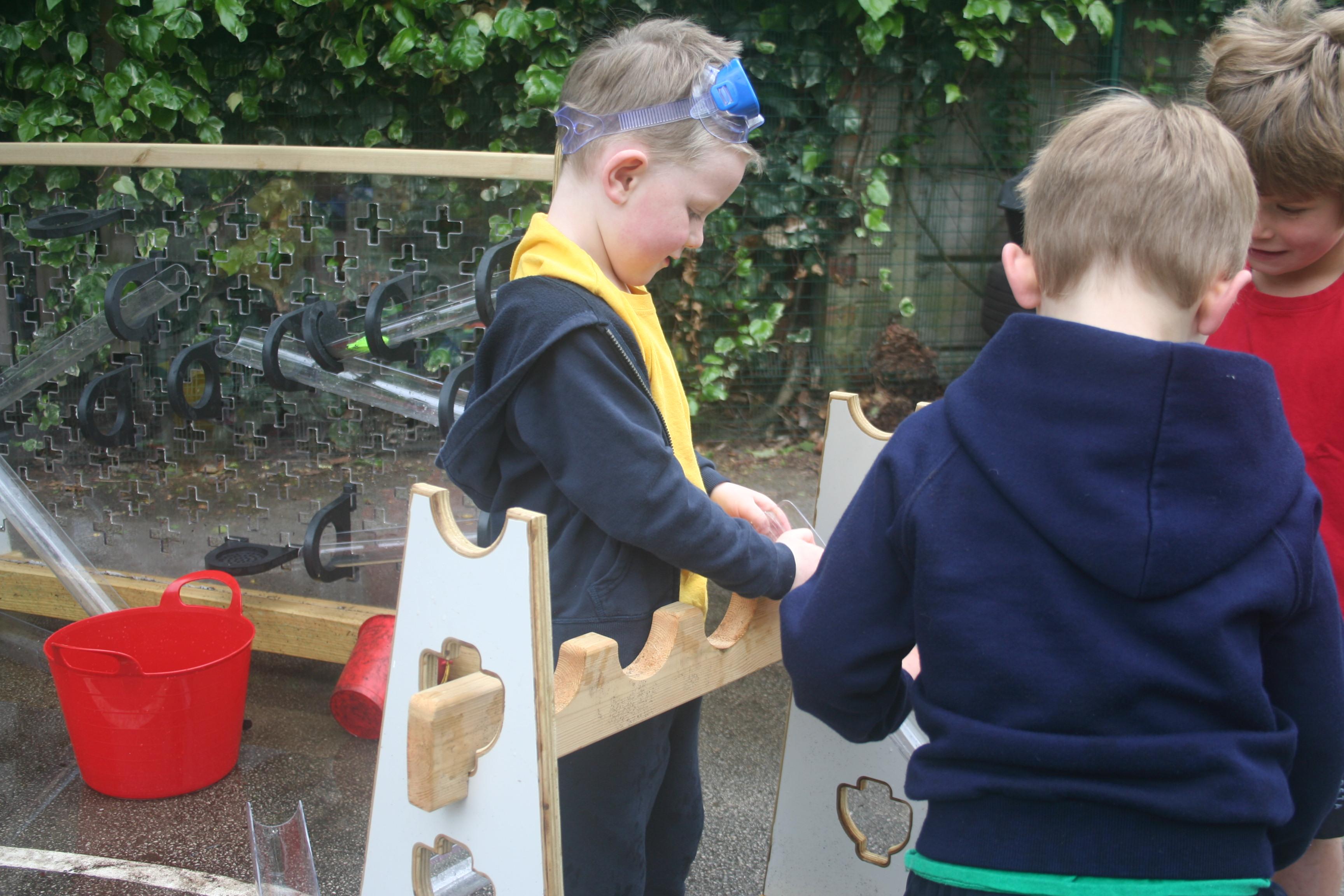 Children playing with water channels that make up part of the Pioneer Messy Play Package