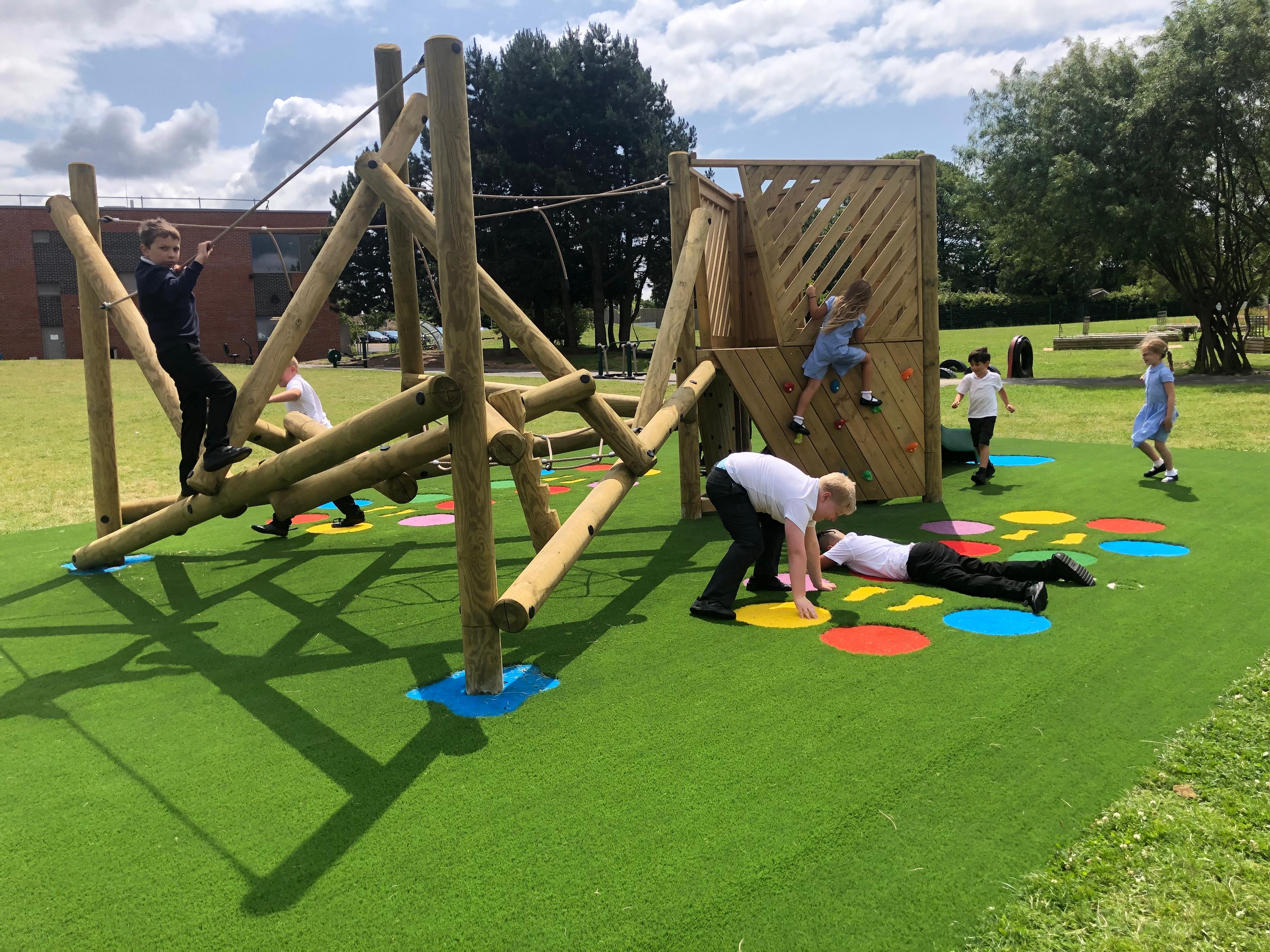 Wooden Bowfell Climbing Frame with Platform and Slide in school playground.