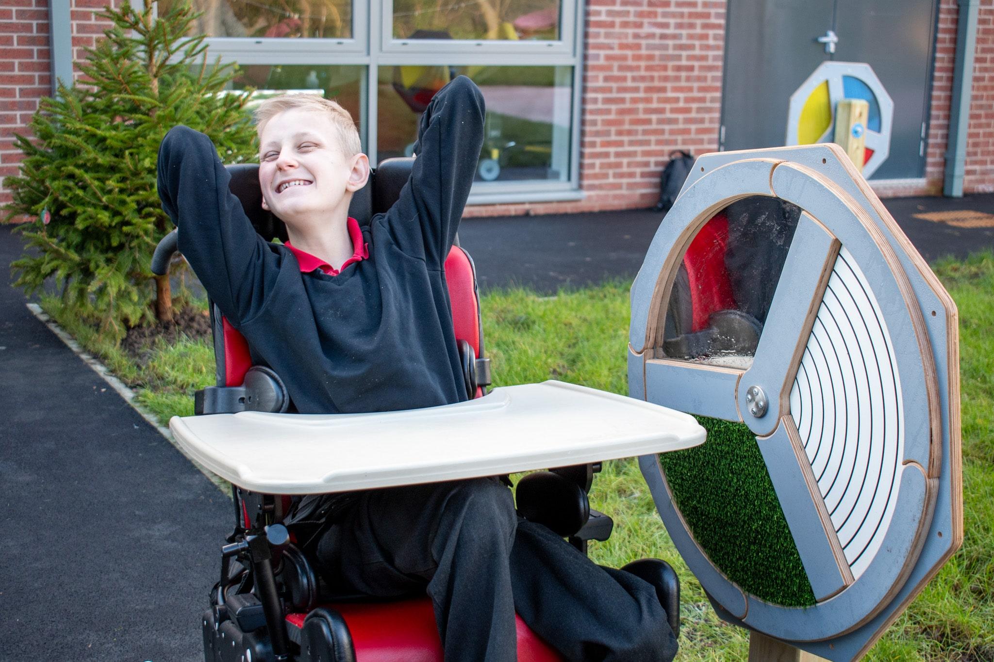 A boy is happy and stimming as he is next to the Touch Sensory Spinner.