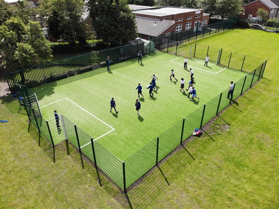 A birds eye view of a class of children playing on their multi-use games area.