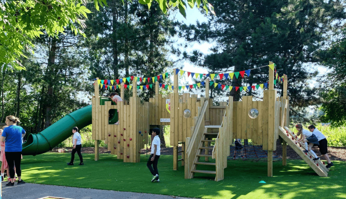 A Pentagon Play bespoke School Playground Scheme with children playing on the playground