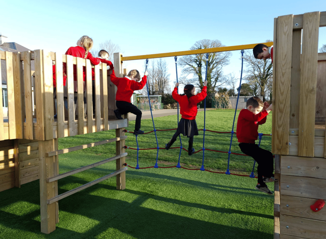 A Pentagon Play bespoke School Playground Scheme with children playing on the playground