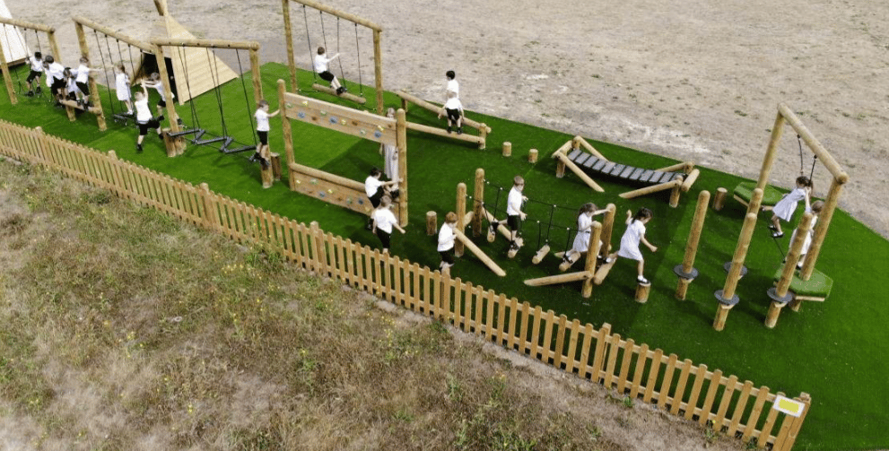 A Pentagon Play bespoke School Playground Scheme with children playing on the playground