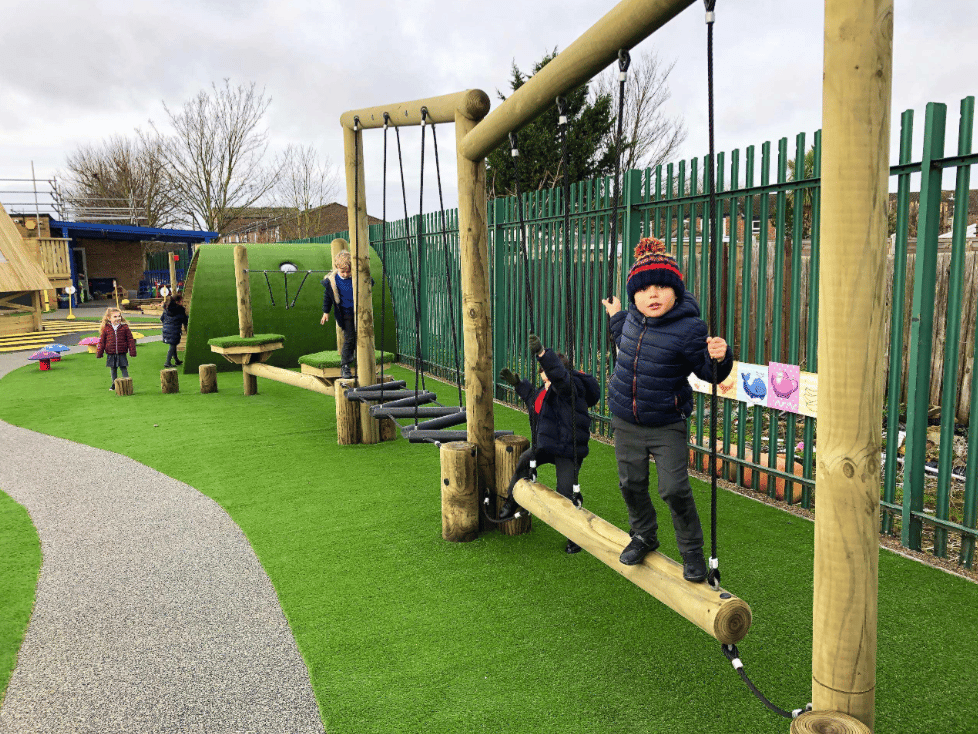 A Pentagon Play bespoke School Playground Scheme with children playing on the playground