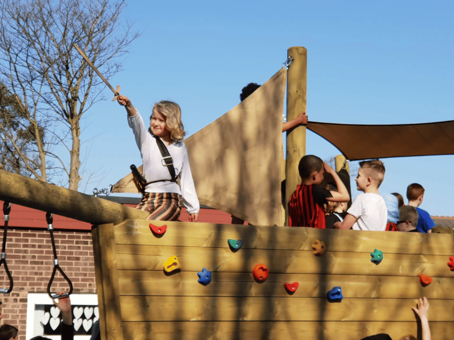 A Pentagon Play bespoke School Playground Scheme with children playing on the playground