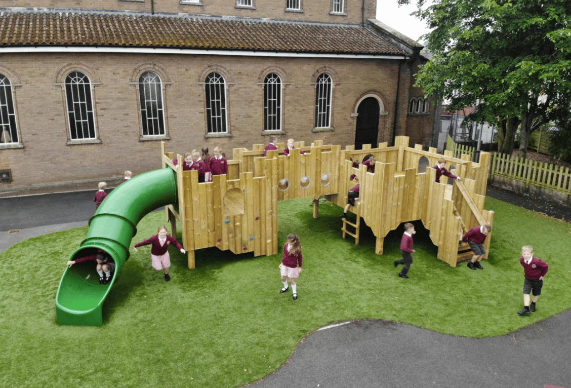 A Pentagon Play bespoke School Playground Scheme with children playing on the playground