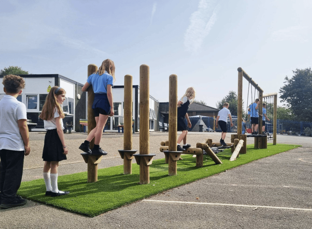 A Pentagon Play bespoke School Playground Scheme with children playing on the playground