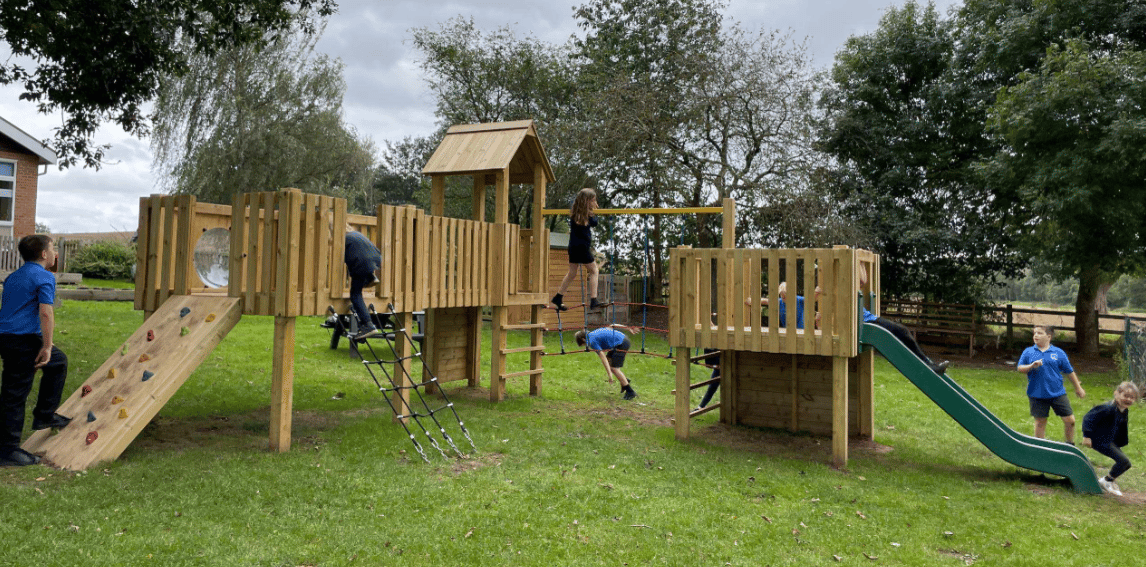 A Pentagon Play bespoke School Playground Scheme with children playing on the playground
