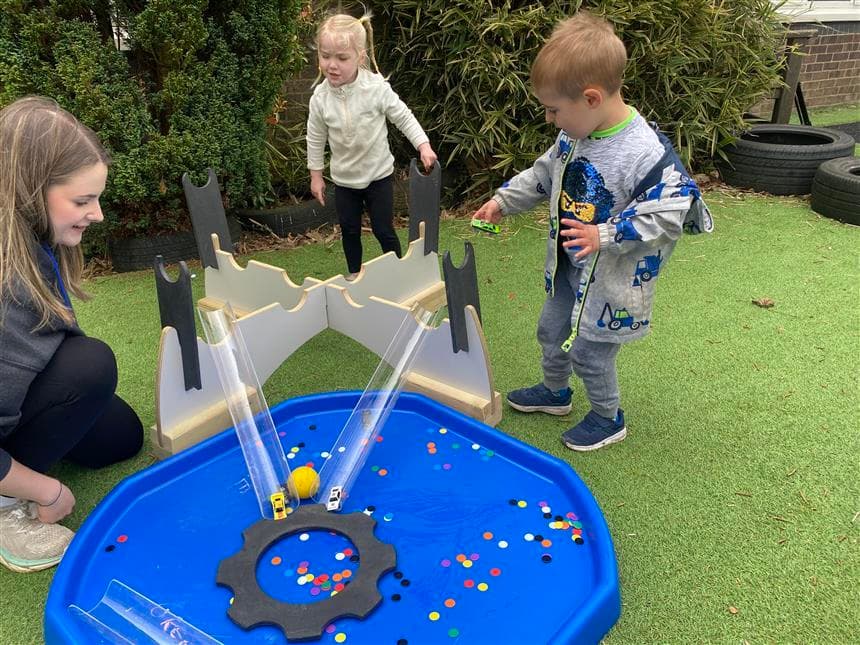 2 children playing on the tuff spot tray in their playground setting