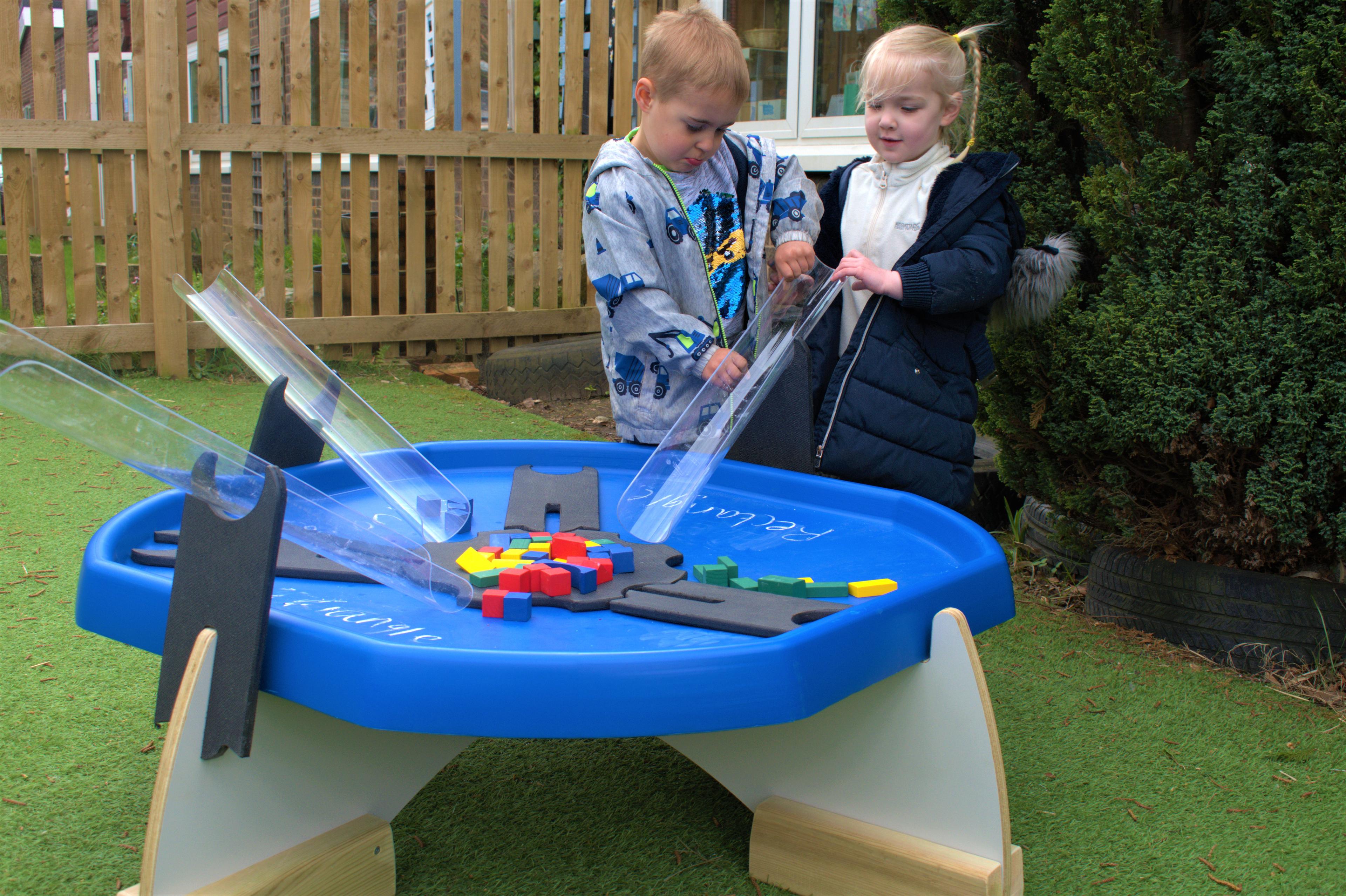 2 children playing on the tuff spot trays