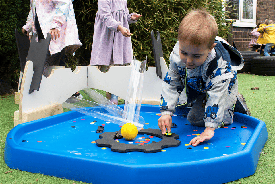 a young boy playing with the movable tuff spot tray