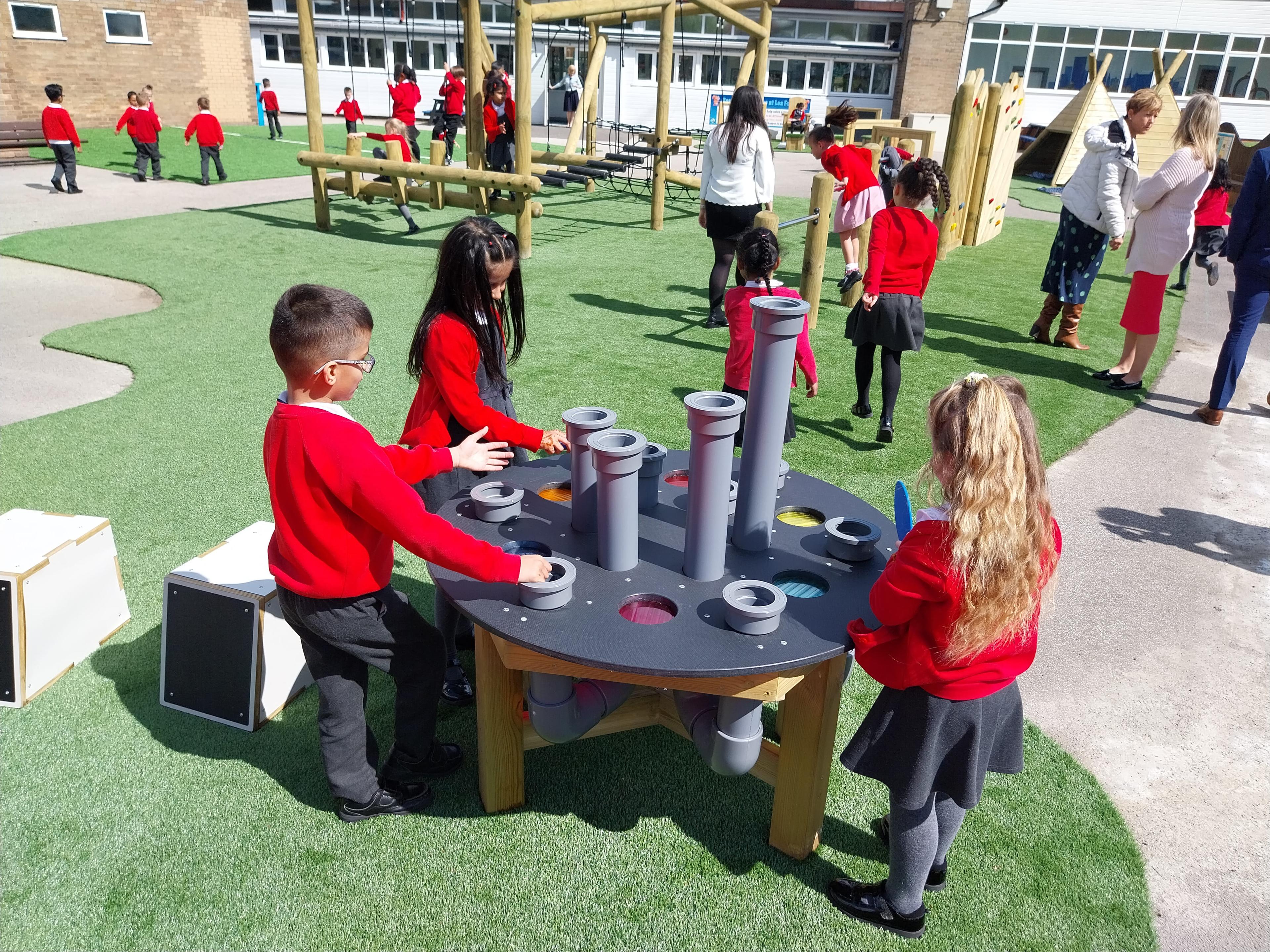 A group of children using the musical play equipment tin their playground