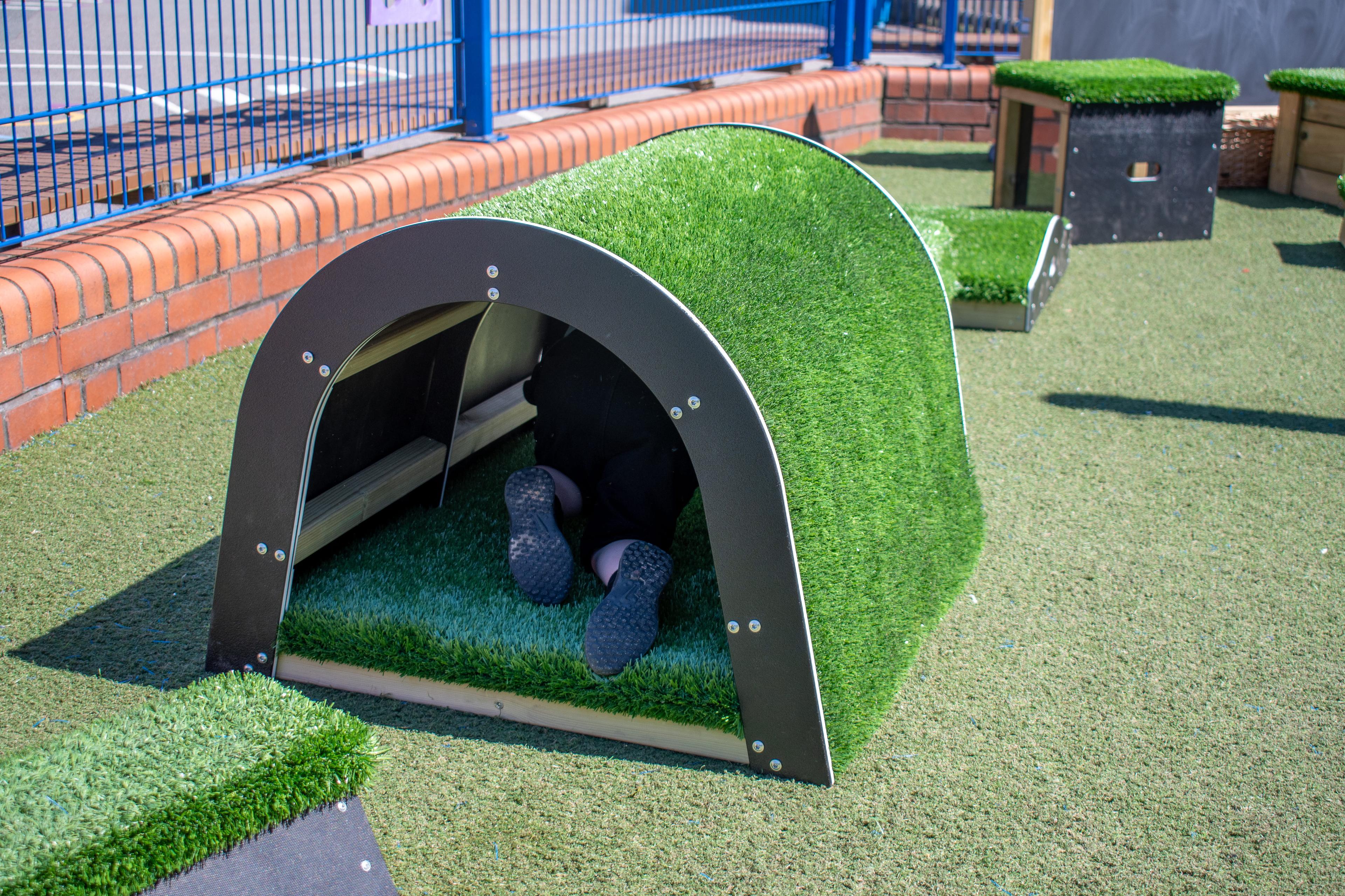 A child's shoes can be seen as they crawl through the tunnel block.