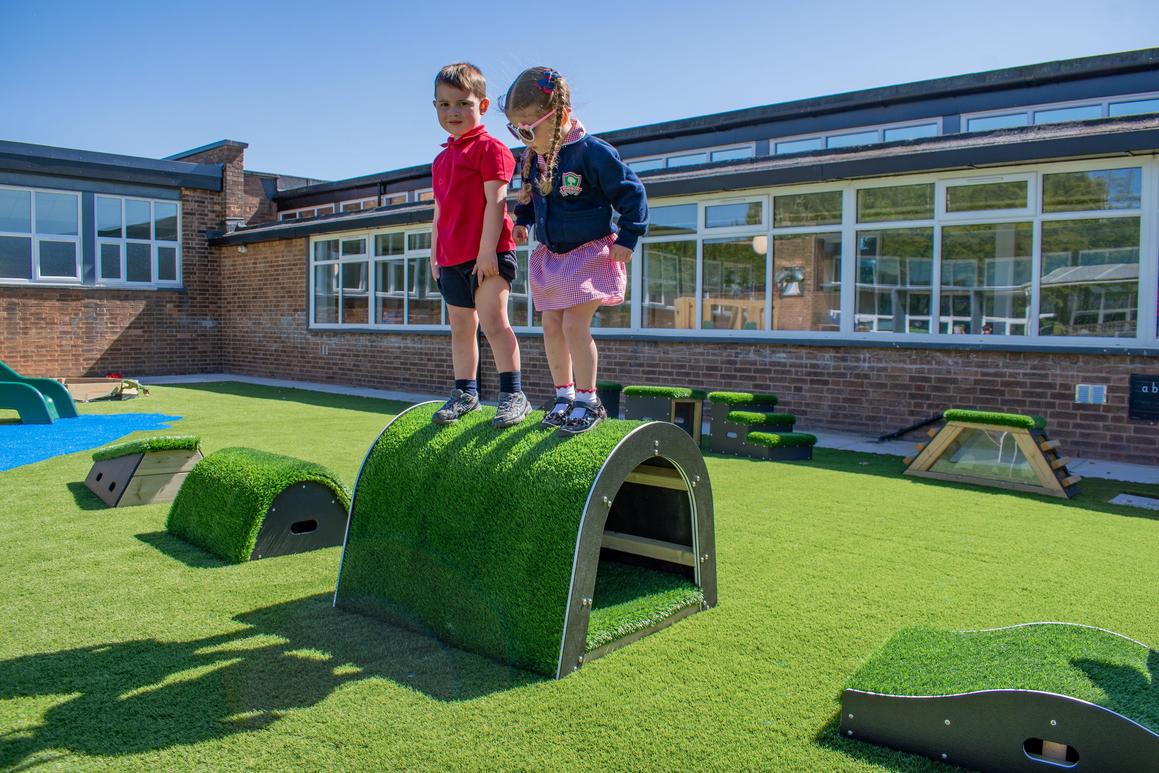 A boy and a girl are stood on top of the tunnel block in the Next Steps Package.