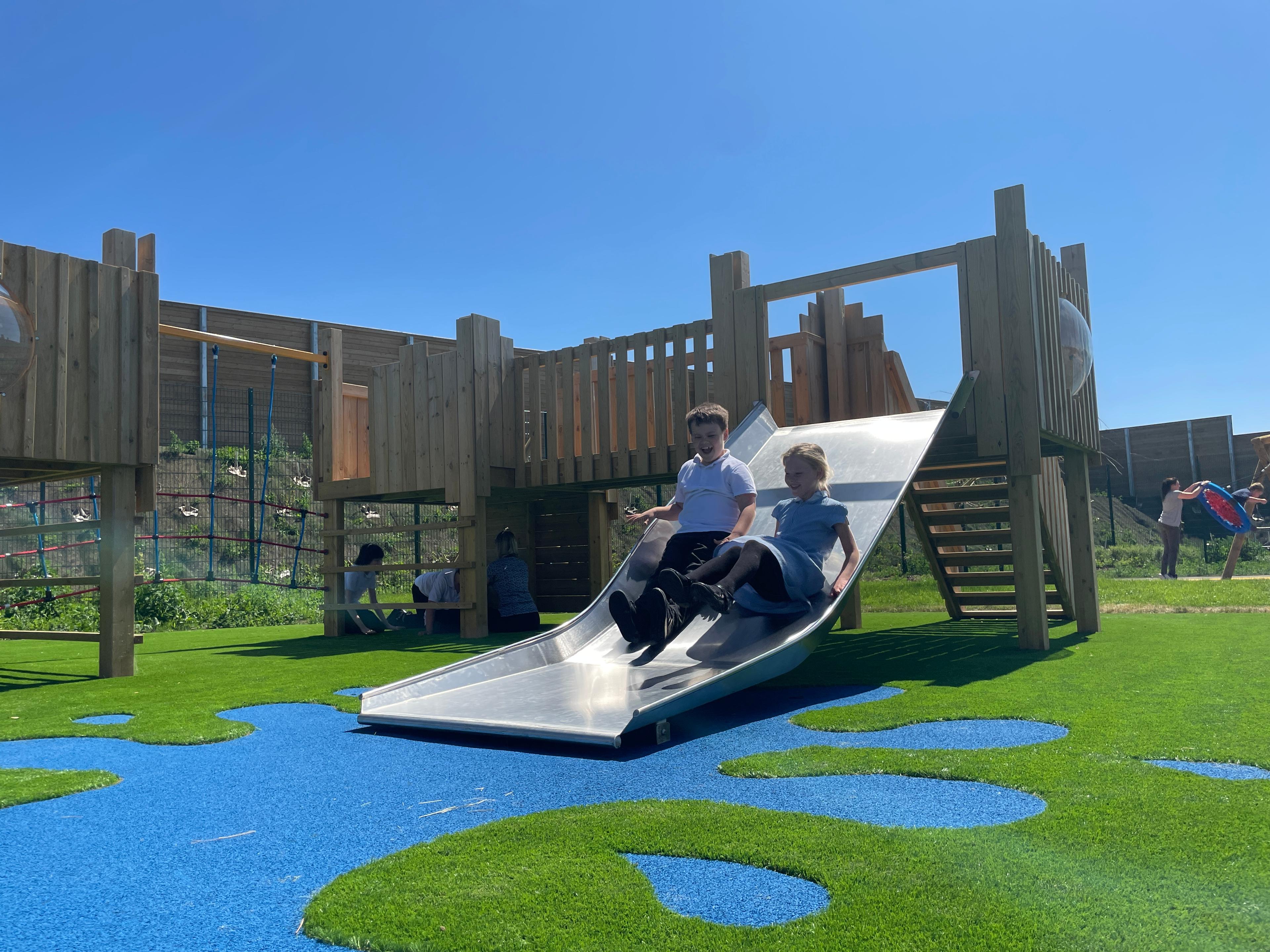 2 boys sliding down the slide