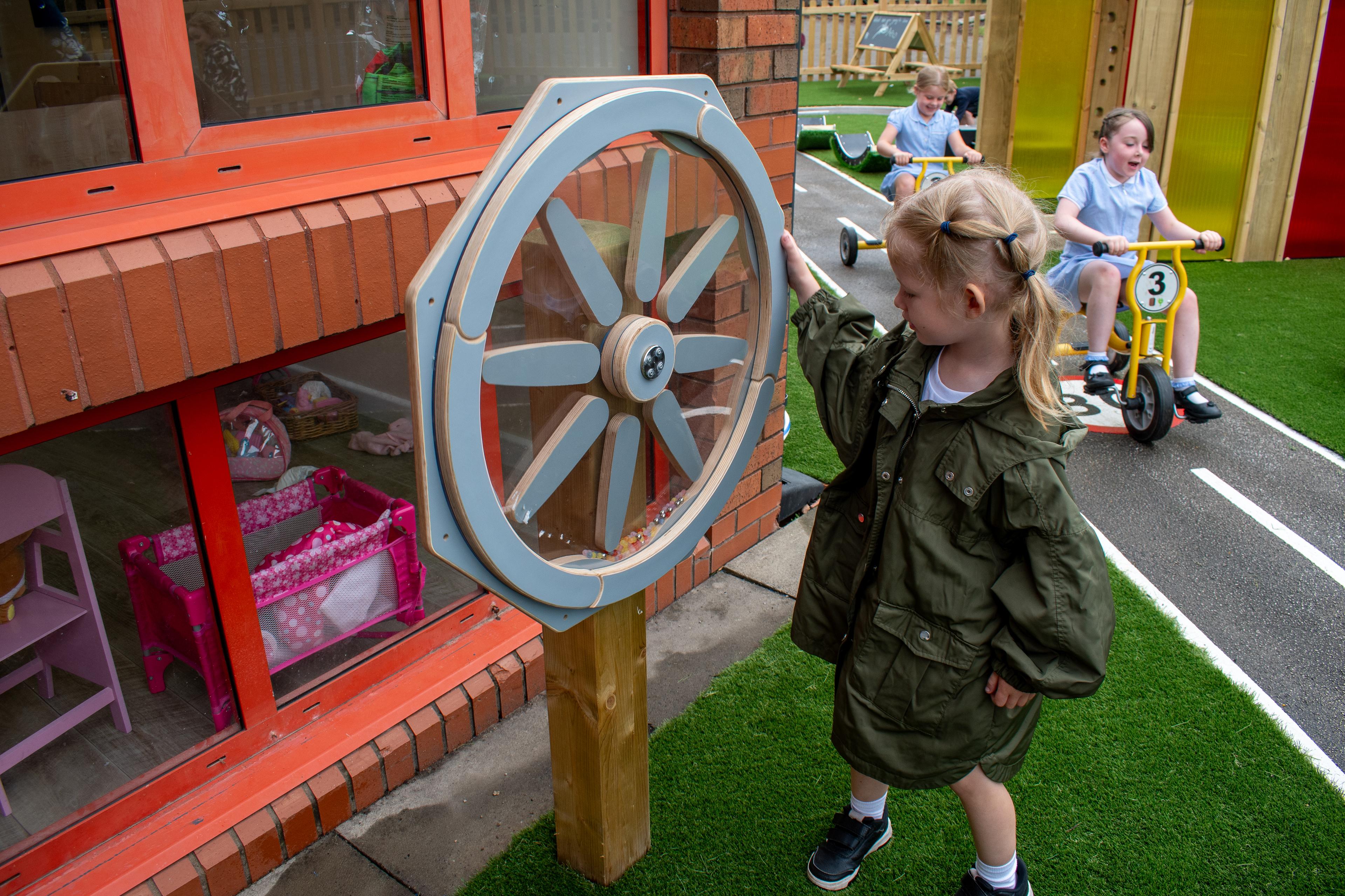 A little girl is playing with the Sound Sensory Spinner.