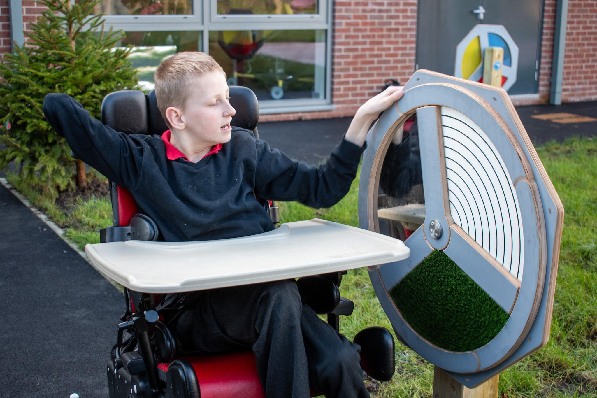 A photo of a child pushing a sensory spinner.