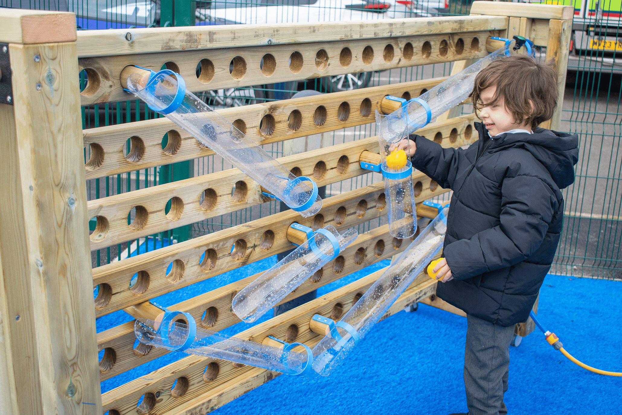 A photo of a child playing with a water wall.