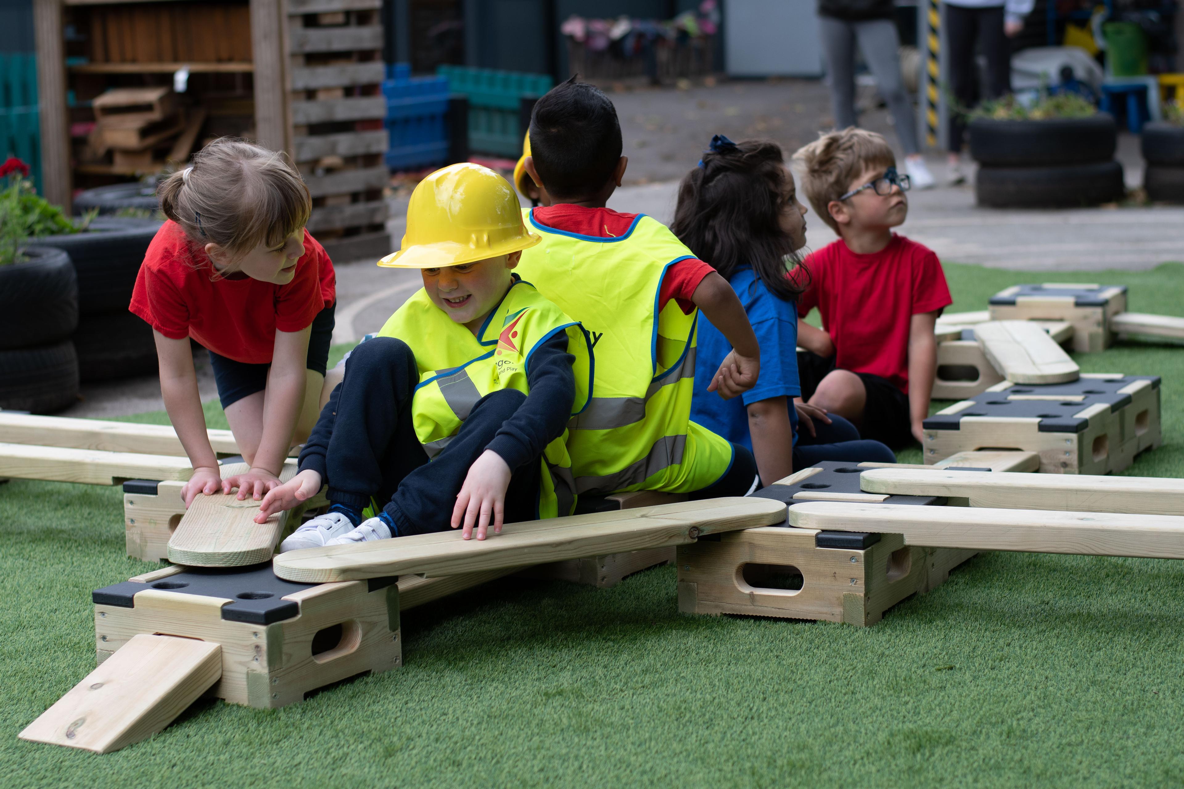 A photo of a group of children using play builder laid out as a boat.